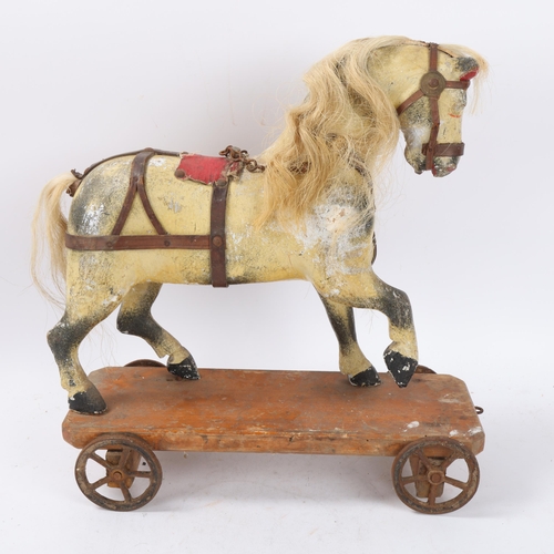 157 - Antique pull-along carved wood toy horse on wheeled base, base length 36cm