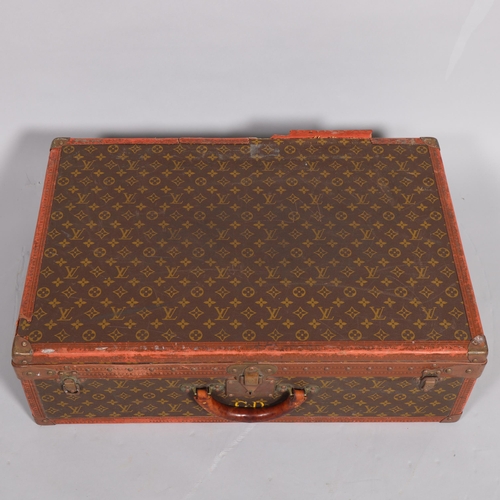 171 - LOUIS VUITTON - a hard suitcase/trunk with monogrammed fabric, leather edging and brass corner mount... 