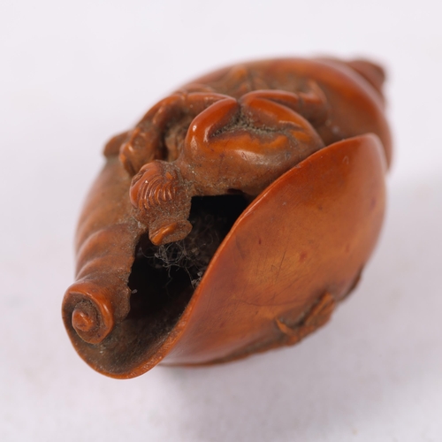 176 - A miniature Japanese Meiji period boxwood carving of figure emerging from conch shell, carved flower... 