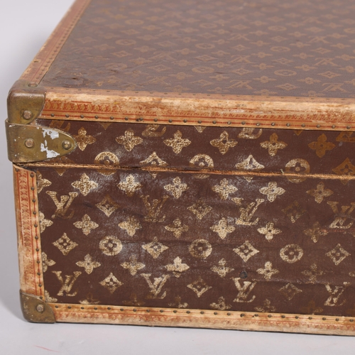 167 - LOUIS VUITTON - a hard suitcase/trunk with monogrammed fabric cover, leather edging, brass locks and... 