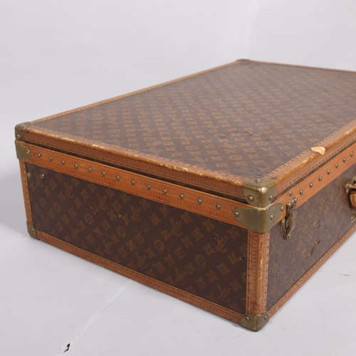 167 - LOUIS VUITTON - a hard suitcase/trunk with monogrammed fabric cover, leather edging, brass locks and... 