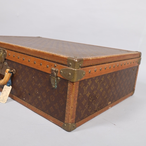 167 - LOUIS VUITTON - a hard suitcase/trunk with monogrammed fabric cover, leather edging, brass locks and... 