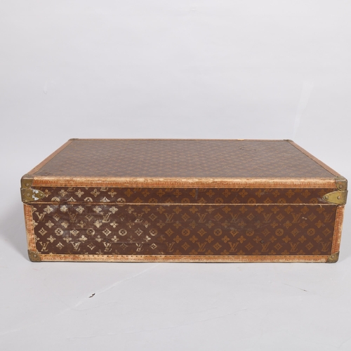 167 - LOUIS VUITTON - a hard suitcase/trunk with monogrammed fabric cover, leather edging, brass locks and... 