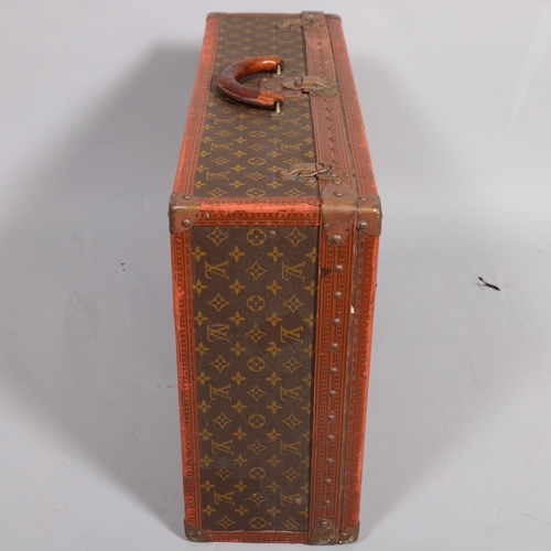 171 - LOUIS VUITTON - a hard suitcase/trunk with monogrammed fabric, leather edging and brass corner mount... 