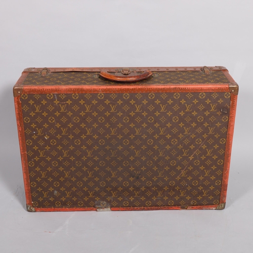 171 - LOUIS VUITTON - a hard suitcase/trunk with monogrammed fabric, leather edging and brass corner mount... 