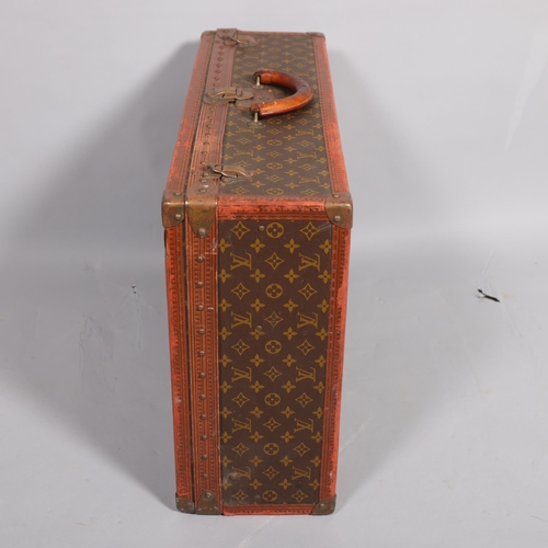 171 - LOUIS VUITTON - a hard suitcase/trunk with monogrammed fabric, leather edging and brass corner mount... 