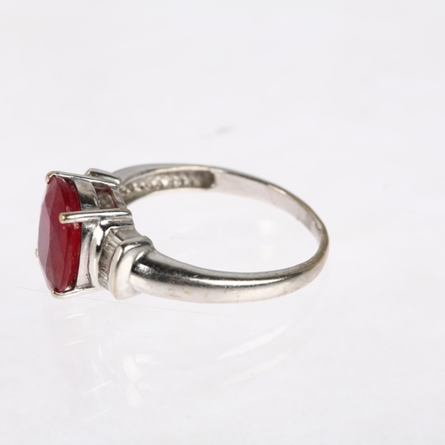 1379 - A modern 18ct white gold ruby and diamond dress ring, claw set with 2.7ct oval mixed-cut ruby flanke... 