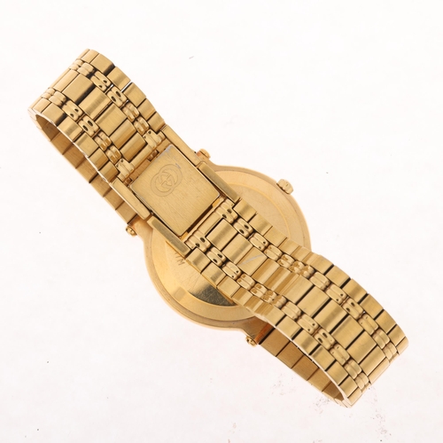 1048 - GUCCI - a gold plated 9200M quartz calendar bracelet watch, black dial with gilt baton hour markers,... 