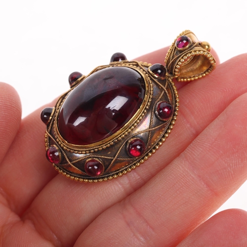 1162 - An Antique Victorian 15ct carbuncle garnet mourning locket pendant, circa 1860, set large oval caboc... 