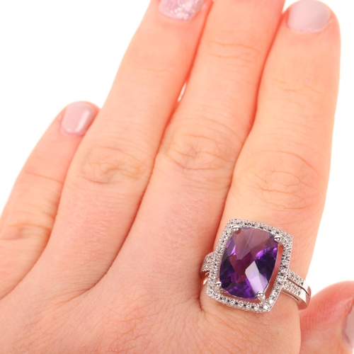 1193 - A 14ct white gold amethyst and diamond halo cluster ring, maker UB, London 2014, claw set with oval ... 