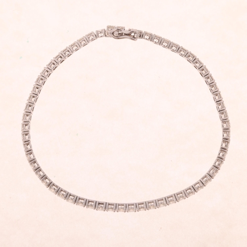 1195 - A 9ct white gold 5.08ct diamond tennis line bracelet, maker MK, claw set with modern round brilliant... 