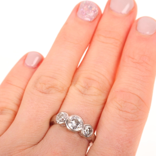 1208 - An 18ct white gold three stone diamond ring, rub-over set with modern round brilliant-cut diamonds, ... 