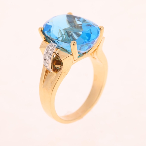 1255 - An 18ct gold blue topaz diamond cocktail ring, claw set with oval mixed-cut topaz and modern round b... 