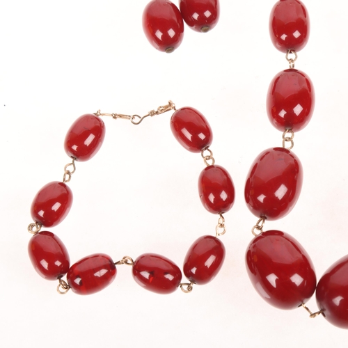 1270 - A cherry amber bead jewellery set, comprising necklace 45cm, bracelet 20cm, and pair of drop earring... 