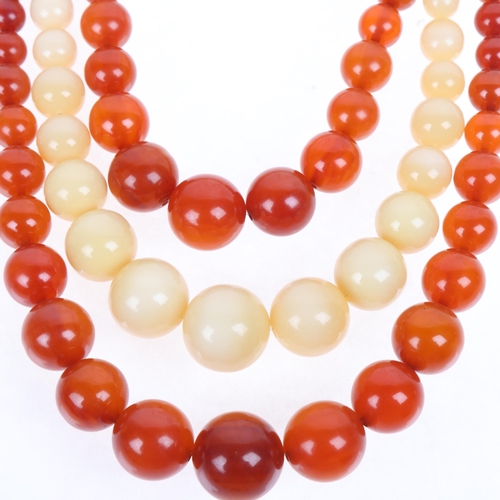 1274 - A Vintage triple-strand graduated amber bead necklace, with orange and milky white amber, largest be... 