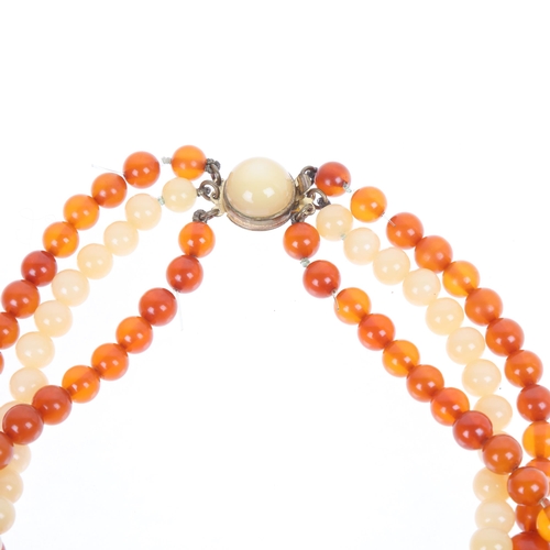 1274 - A Vintage triple-strand graduated amber bead necklace, with orange and milky white amber, largest be... 