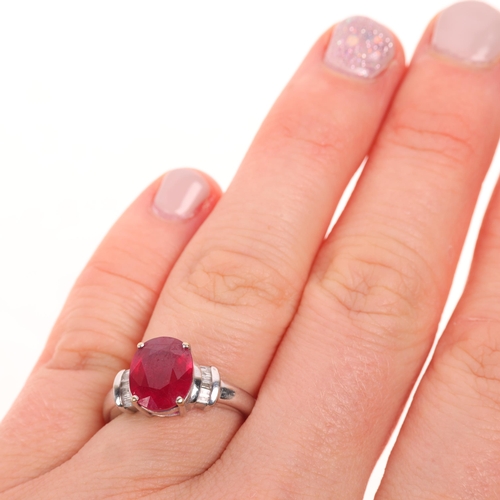 1379 - A modern 18ct white gold ruby and diamond dress ring, claw set with 2.7ct oval mixed-cut ruby flanke... 