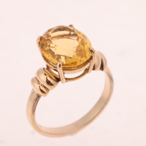 1423 - A 9ct gold single stone citrine dress ring, claw set with oval mixed-cut citrine, setting height 13.... 