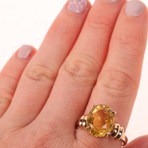 1423 - A 9ct gold single stone citrine dress ring, claw set with oval mixed-cut citrine, setting height 13.... 