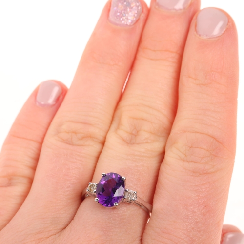 1437 - A 14ct white gold three stone amethyst and diamond ring, claw set with oval mixed-cut amethyst and m... 