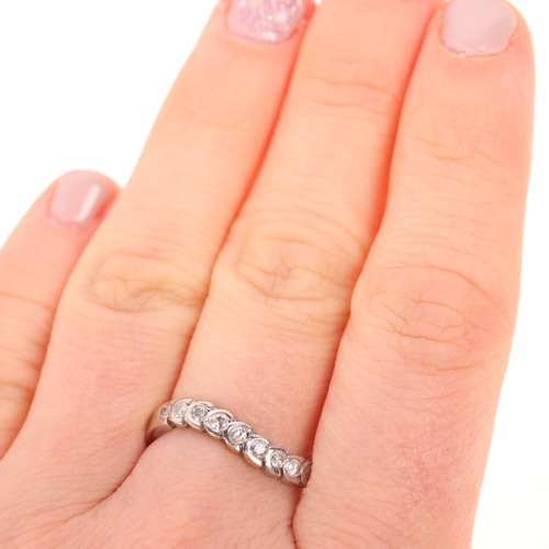 1538 - A 9ct white gold diamond wavy half eternity ring, set with modern round brilliant-cut diamonds, tota... 