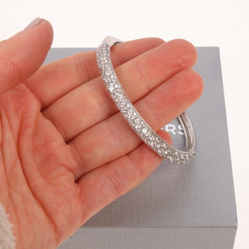 1595 - MICHAEL KORS - a modern designer sterling silver cubic zirconia hinged bangle, signed MK, band width... 