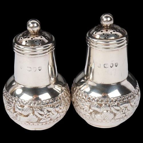 1838 - A pair of late Victorian silver 'Thistle' pepperettes, Sibray, Hall & Co, London 1892, with relief e... 