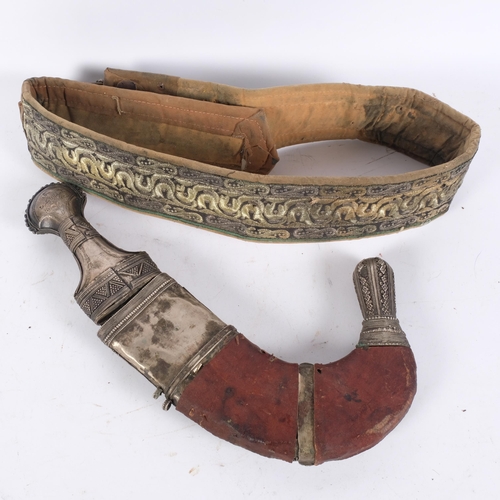 42 - An Antique Jambiya dagger with sheath, length approx 40cm, and ceremonial fabric belt (2)