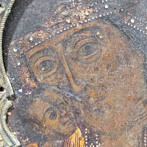 19 - An Antique Russian icon depicting the Mother of God, oil on wood panel with relief pierced silver ha... 