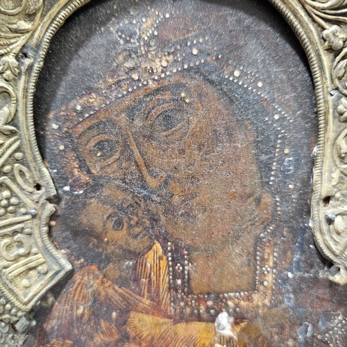 19 - An Antique Russian icon depicting the Mother of God, oil on wood panel with relief pierced silver ha... 