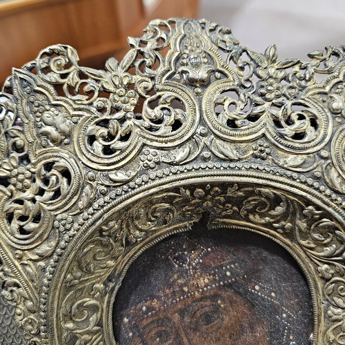 19 - An Antique Russian icon depicting the Mother of God, oil on wood panel with relief pierced silver ha... 