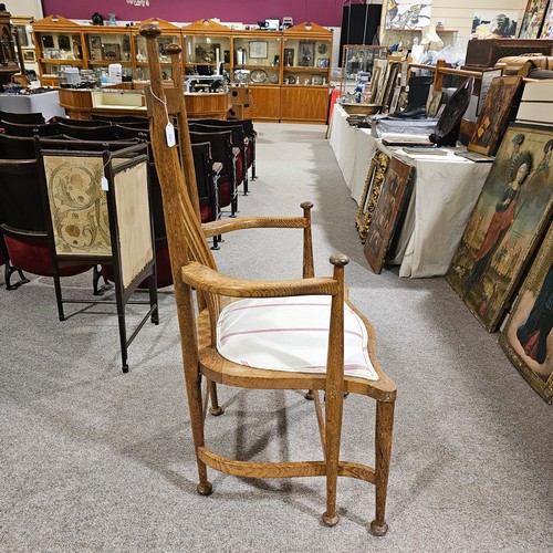 151 - An oak Arts & Crafts chair by James Shoolbred, Tottenham Court Road, London, with 6 legs and scrolle... 