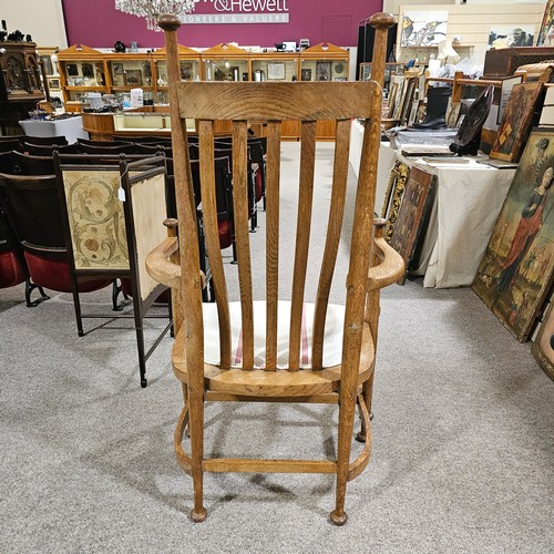 151 - An oak Arts & Crafts chair by James Shoolbred, Tottenham Court Road, London, with 6 legs and scrolle... 