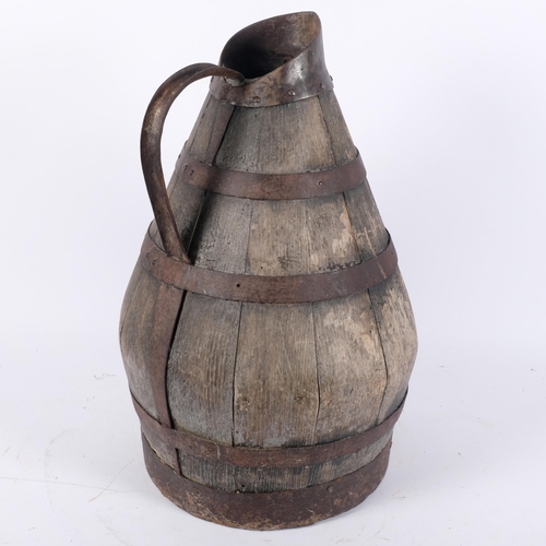 581 - A large Continental coopered oak jug with metal bands, H47cm