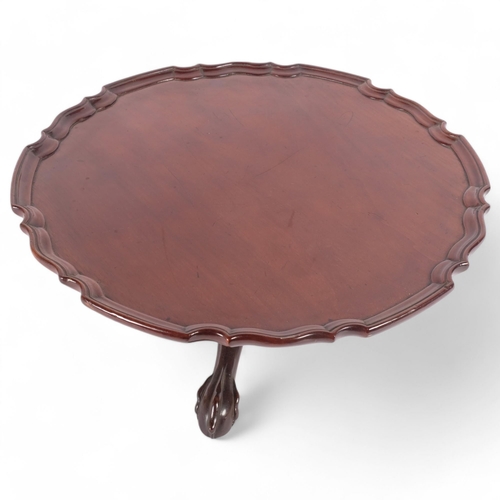 17 - A mahogany lazy Susan with a shaped edge, on a tripod claw base, diameter 46cm, height 13cm