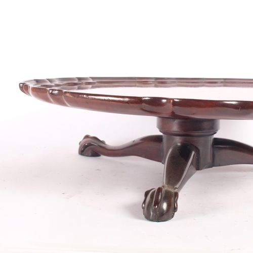 17 - A mahogany lazy Susan with a shaped edge, on a tripod claw base, diameter 46cm, height 13cm