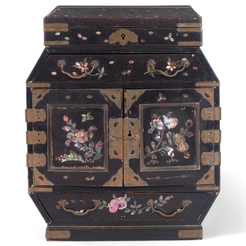 22 - A Chinese black lacquered jewellery cabinet, with a rising lid and fitted drawers and cupboards, pai... 