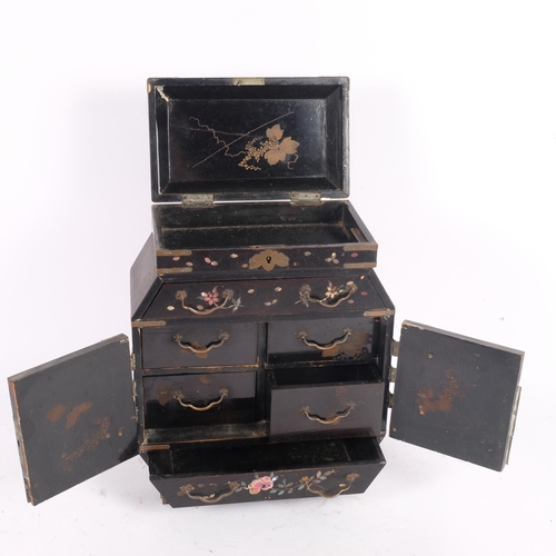 22 - A Chinese black lacquered jewellery cabinet, with a rising lid and fitted drawers and cupboards, pai... 