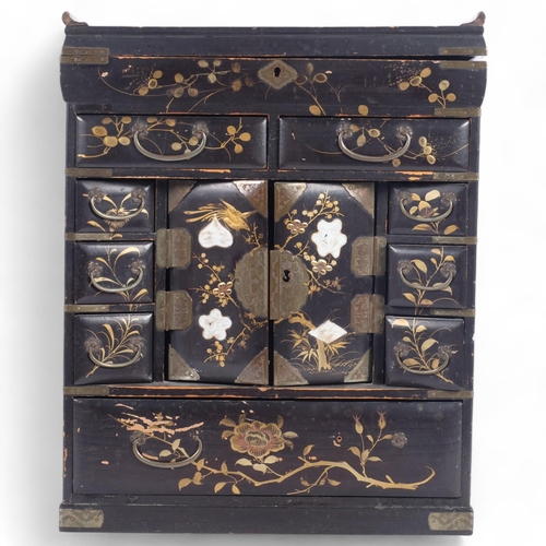 23 - A Chinese black lacquered table-top jewellery/writing cabinet, the rising lid revealing a fitted int... 