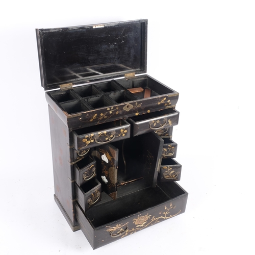 23 - A Chinese black lacquered table-top jewellery/writing cabinet, the rising lid revealing a fitted int... 