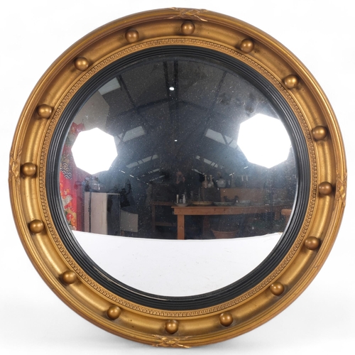 51 - A giltwood convex wall mirror, with ebonised insert and ball applied bosses, diameter 46cm