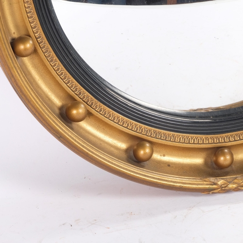 51 - A giltwood convex wall mirror, with ebonised insert and ball applied bosses, diameter 46cm