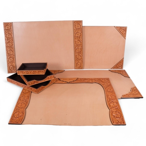 73 - A graduated set of 3 tan tooled leather desk trays, longest 38cm, together with 4 tan tooled leather... 