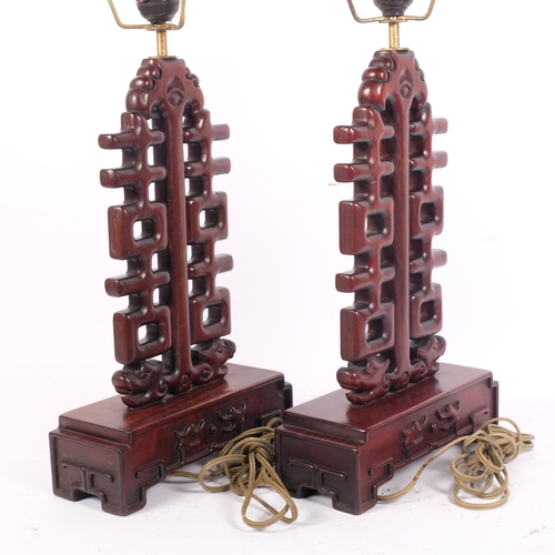 206 - A pair of Chinese design hardwood table lamps of lattice pierced and stepped form, H50cm