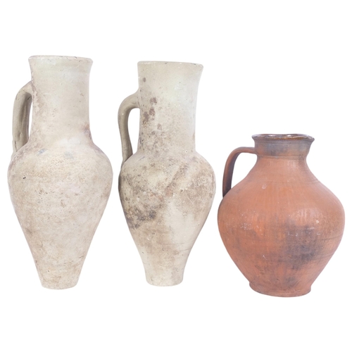 207 - A pair of single-handled pottery ewers, and a terracotta jug