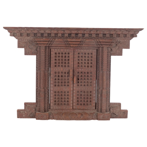 327 - A carved Oriental hardwood wall-hanging frame, with central opening doors, 33cm x 49cm