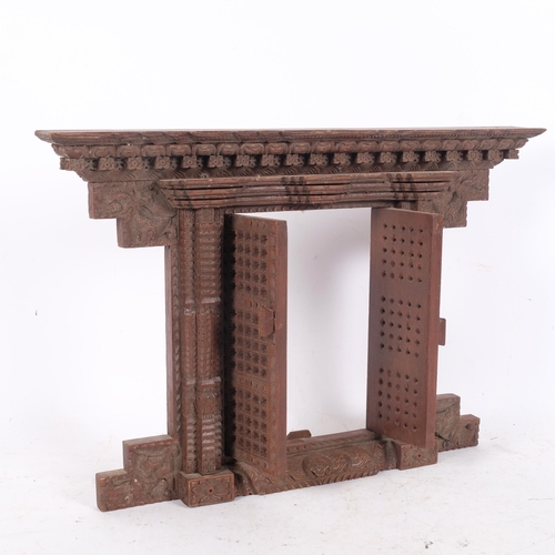 327 - A carved Oriental hardwood wall-hanging frame, with central opening doors, 33cm x 49cm