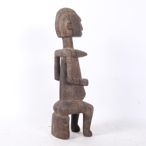 394 - A carved wood figure of an African woman seated on a stool, H42.5cm