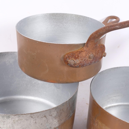 436 - A graduated set of 4 copper saucepans with steel handles, largest 18.5cm, and another similar saucep... 