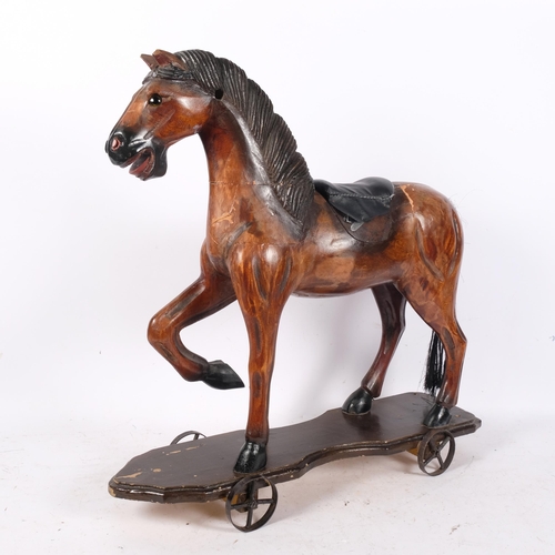 460 - A painted carved wood horse, on plinth with wheels, H59cm